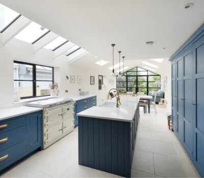 Bright white kitchen with ceiling windows on blue cupboards and cream Everhot
